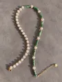 Detailed macro view of freshwater pearls and green stone beads with gold lobster clasp - Green Textured Cylinder Pearl Elegant Style (14)