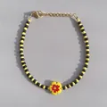 Macro shot of yellow and black glass beaded bracelet with red flower charm and golden clasp - Yellow Black Two Tone Seed Bead Flower Style (27)