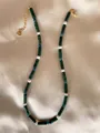 Close-up of handmade necklace with natural stones and pearls on champagne satin - Green Textured Cylinder Blue Bead Elegant Style (20)