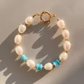 Detail van handgemaakte zoetwaterparelarmband met blauwe kralen en gouden sluiting - Blauw En Witte Textuur Parel Splicing Stijl (25)