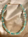Nahaufnahme der handgefertigten Kette mit Türkisperlen, Süßwasserperlen und 18k Goldverschluss - Türkis Weiß Lila Bernstein Elegant (24 Halskette)