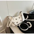 Detalle del bolso blanco con dijes de mariposa plateados y elegante correa de cadena - Talla única / Blanco Roto