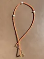 Detailed close-up of orange beads and freshwater pearls with gold heart pendant - High Saturated Orange Bead Heart Style (35)