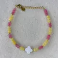 Detailed macro view of beaded bracelet with clover charm and golden metal extension chain - Pink Yellow Faceted MOP Clover Style (42)