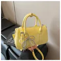 Dettaglio della borsa Boston gialla con ciondolo a fiocco in perle e trama in ecopelle - Con Ciondolo / Giallo