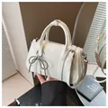 Borsa a mano Boston bianca lucida con ciondolo a fiocco argento e tracolla - Con Ciondolo / Bianco