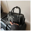 Glänzende schwarze Boston-Handtasche mit Perlen-Schleifenanhänger und Schultergurt - Schwarz