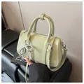 Schicke mintgrüne Boston-Tasche aus glänzendem Kunstleder mit einem Perlen-Schleifen-Anhänger - Grün