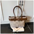 Detailed macro view of large canvas tote bag with brown leather belt and metal buckles - One Size / Khaki