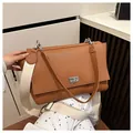 Elegant brown pebbled leather shoulder bag featuring a stylish wide cream canvas strap - Brown