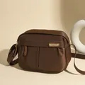 Deep brown oxford cloth crossbody bag with satin finish and golden metallic zipper detail - Coffee