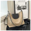 Detail of khaki suede and black leather tote bag with metal chain on display - Khaki