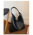 Detailopname van zwarte leren shopper met rijke textuur en geïntegreerde brede schouderband - Eén maat / Zwart