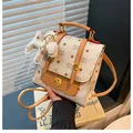 Sac à dos monogramme blanc crème avec garniture en cuir marron et pendentif chiot - Beige