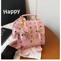 Mini sac à dos en cuir rose avec monogramme NK et breloque chien sur table en bois - Rose foncé