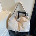Minimalist beige nylon tote bag with large external pockets on a black suitcase - One Size / Grayish White