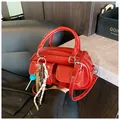 Glossy red leather boston handbag with front pockets and colorful charm accessory - With Pendant / Red