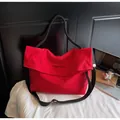 Detail of red tote bag featuring thick black woven handle and spacious folding flap design - One Size / Burgundy