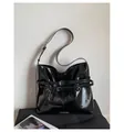 Detail of black glossy faux leather tote bag with silver metal buckles and straps - Black