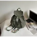Detail of dark green gingham canvas backpack with drawstring closure and front buckle pockets - Green