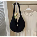 Macro view of black knit tote featuring a large pearl button and vertical texture detail - One Size / Black