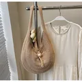 Detail of hand-woven straw tote bag with elegant pearl accessory and rustic knot closure - One Size / Khaki