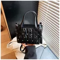 Detail of black quilted crossbody bag with sparkling rhinestones and silver hardware - Black