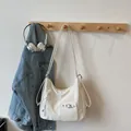 Bolso hobo beige chic con textura plisada y cordón ajustable en un colgador de pared - Talla única / Blanco Roto