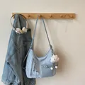 Light blue textured tote bag with cloud pendant and adjustable strap in a casual scene - One Size / Blue