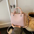 Bolso rosa con textura de lichi, asa de nudo y correa ajustable en un ambiente elegante - Sin colgante / Púrpura