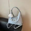 Hellblaue Halbmond-Schultertasche mit Wolkentextur und Sternanhänger im Fotostudio - Einheitsgröße / Blau