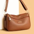 Close-up of brown lychee leather texture and golden kangaroo logo on a multi-zip crossbody bag - One Size / Coffee Brown