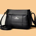 Detalle de bolso bandolera de cuero granulado negro con logo de canguro dorado - Talla única / Negro