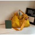 Large yellow canvas crossbody bag with shoulder strap shown next to a tablet for size - Yellow