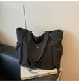 Minimalist black nylon tote bag with drawstring side pockets and magnetic snap closure - Black