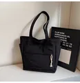 Primer plano del bolso tote de lona negra con correa ancha y bolsillo con cremallera - Talla única / Negro