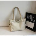 Detail of minimalist cream tote bag with side pockets and smooth magnetic front flap - Off White