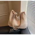 Beige gewebte Tragetasche mit braunen Lederriemen im natürlichen Licht- und Schattenspiel - Einheitsgröße / Khaki