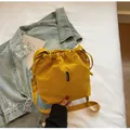 Bolso tipo cubo amarillo con cordón en tejido de nailon texturizado y correa larga - Amarillo