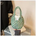 Detail view of green hand-woven knit bucket bag with a white drawstring inner pouch - Green