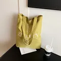 Olive green tote bag with white grocery text and herbal print on a minimalist table - One Size / Green