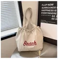 Bolso tote de nailon crema con letras Beach en rojo y cierre de cordón ajustable - Talla única / Gris claro