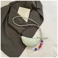 Lichtgroene croissanttas met verticale stiksels en modieuze bedel met letterkralen - Met Hanger / Lichtgroen