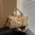 Khaki nylon sports bag with adjustable strap on a leather sofa in natural light - Khaki