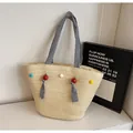 Strohtasche mit gestreiften blauen Henkeln und bunten Pompons für den Strandurlaub - Einheitsgröße / Gebrochenes Weiß