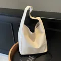 Crèmewitte geweven lederen bucket tote tas met minimalistische brede schouderriem - Eén maat / Broken Wit