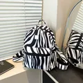 Fashionable black and white zebra pattern backpack with front zipper pocket and silver tag - Zebra Print