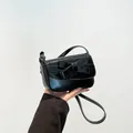 Borsa nera classica con fiocco grande e finitura lucida mostrata tenuta in mano - Stile Fiocco / Nero