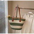 Dettaglio della borsa tote tessuta a righe verdi e bianche con manico in pelle marrone - Con Ciondolo / Verde