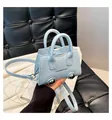 Close-up of light blue mini bag with silver metal ball feet and fine leather texture - One Size / Blue